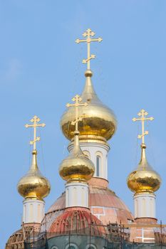 city is reflected in the golden dome of the church under construction
