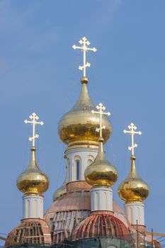 city is reflected in the new golden domes of the church on a sunny day