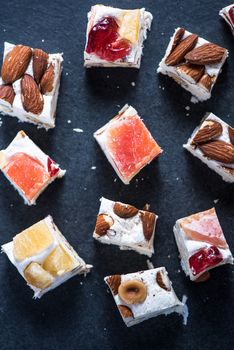 Italian nougat bars cut in pieces on dark slate background