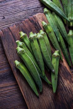 Fresh okra on wooden rustic cutting board