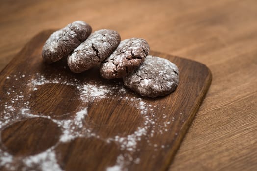 chocolate cookies with sugar powder on wooden kitchen Board