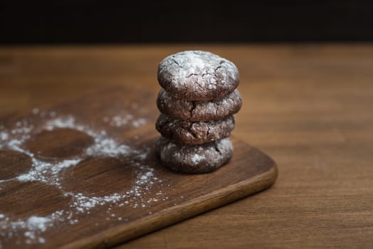 chocolate cookies with sugar powder on wooden kitchen Board