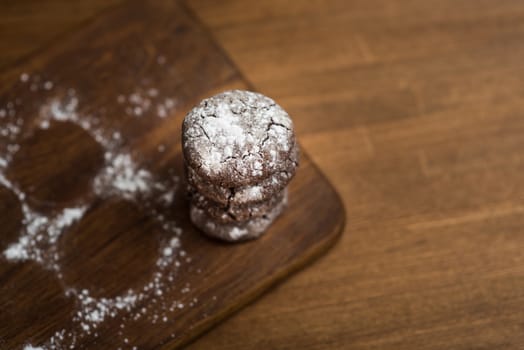 chocolate cookies with sugar powder on wooden kitchen Board