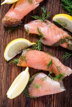 Smoked salmon on wooden board with dil and lemon from above