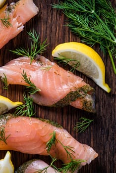 Smoked salmon on wooden board with dil and lemon from above