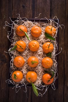 Farm fresh tangerines in wooden rustic crate with straw