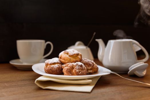 eclairs with custard cream with tea and teapot