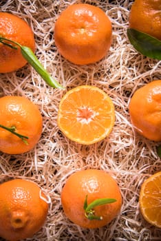 Tangerines in wooden rustic crate from above, whole and half cut