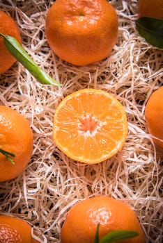 Tangerines in wooden rustic crate from above, whole and half cut