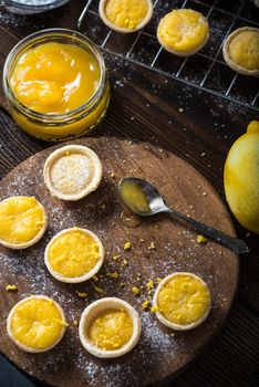 Lemon and custard tarts on cooling tray on wooden rustic table