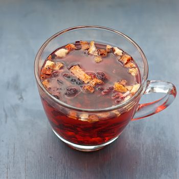 Red fruit tea in transparent glass Cup on a wooden table