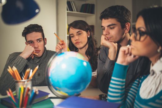 Four beautiful students of Geography learning with globe and thinking. Vintage concept.