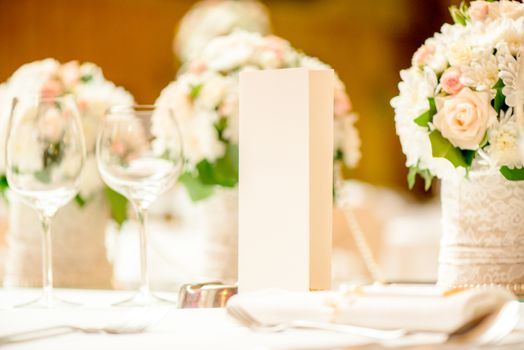 Close-up of a floral wedding table decoration with menu