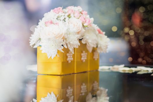 Close-up of a wedding table decoration with white flowers and petals. 