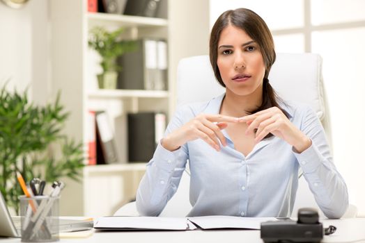 Portrait of a beautiful young businesswoman sitting in the office and thinking.