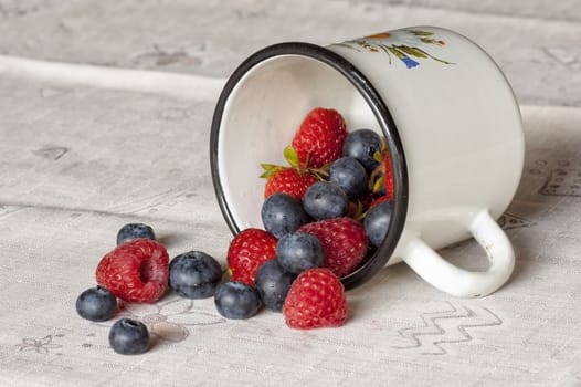 fresh berries in mug on table