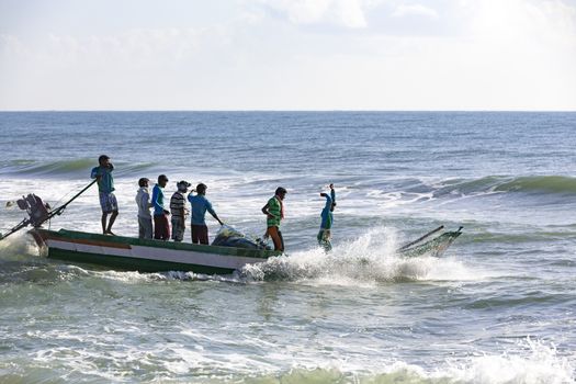 Pondichery, Tamil Nadu, India - February 27, 2014 : Traditional fishermen on beach, on sea, on sand. Long boats, Hard work poor people