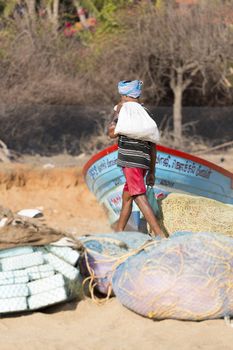 Pondichery, Tamil Nadu, India - February 27, 2014 : Traditional fishermen on beach, on sea, on sand. Long boats, Hard work poor people