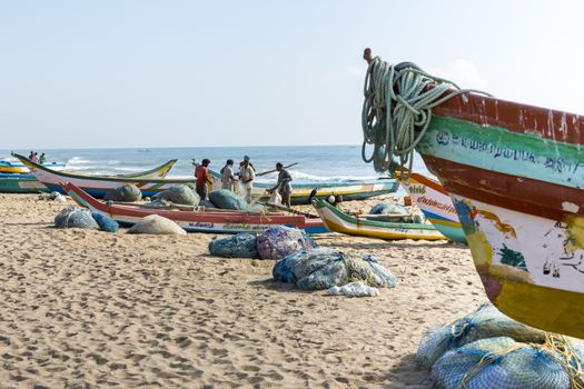 Pondichery, Tamil Nadu, India - February 27, 2014 : Traditional fishermen on beach, on sea, on sand. Long boats, Hard work poor people