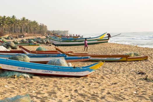 Pondichery, Tamil Nadu, India - February 27, 2014 : Traditional fishermen on beach, on sea, on sand. Long boats, Hard work poor people