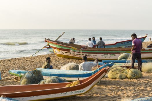 Pondichery, Tamil Nadu, India - February 27, 2014 : Traditional fishermen on beach, on sea, on sand. Long boats, Hard work poor people