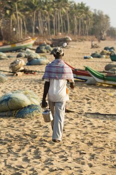 Pondichery, Tamil Nadu, India - February 27, 2014 : Traditional fishermen on beach, on sea, on sand. Long boats, Hard work poor people