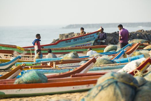 Pondichery, Tamil Nadu, India - February 27, 2014 : Traditional fishermen on beach, on sea, on sand. Long boats, Hard work poor people