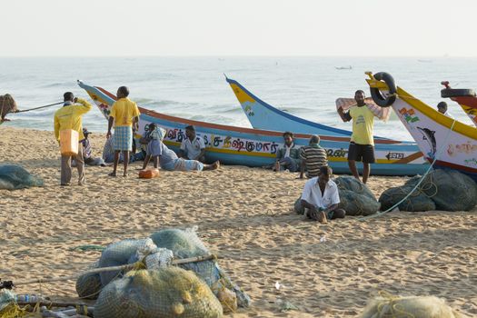 Pondichery, Tamil Nadu, India - February 27, 2014 : Traditional fishermen on beach, on sea, on sand. Long boats, Hard work poor people