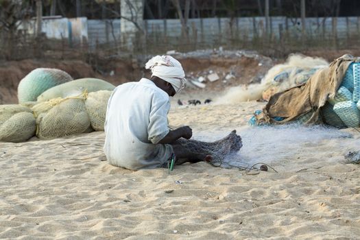 Pondichery, Tamil Nadu, India - February 27, 2014 : Traditional fishermen on beach, on sea, on sand. Long boats, Hard work poor people