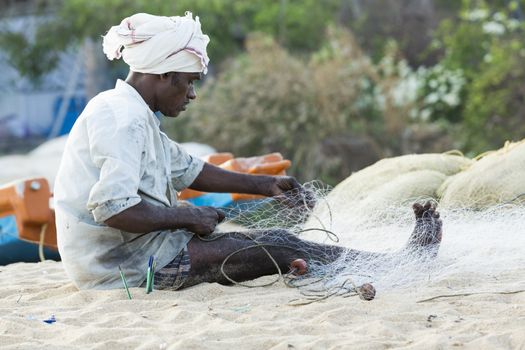 Pondichery, Tamil Nadu, India - February 27, 2014 : Traditional fishermen on beach, on sea, on sand. Long boats, Hard work poor people