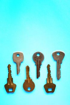 Abstract composition with door keys on blue paper background