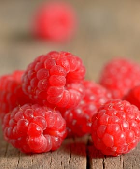 Ripe sweet raspberries on wooden background
