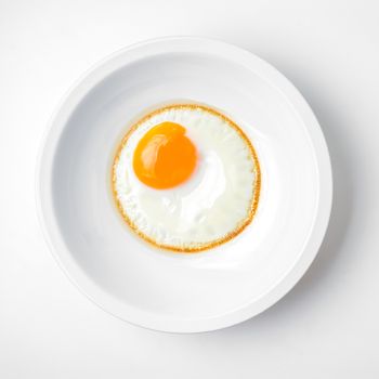 fried egg on white plate isolated on white background