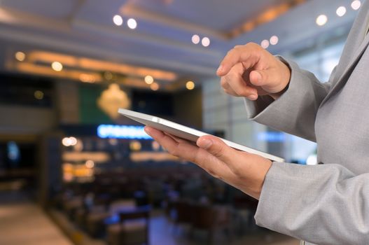 Businessman Use Wireless Tablet Device in Restaurant with Bokeh, Close up shot.