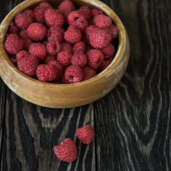 Fresh red currants in plate on wooden table