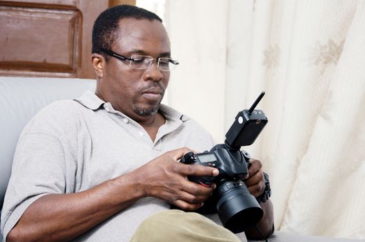 After his photo shoot; this photographer looks at his pictures to appreciate.