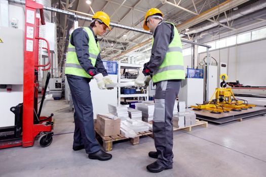 Workers taking aluminium billet at CNC machine shop