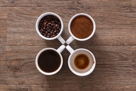 Four cups of coffee, phases of drink - bean, ground and empty cup