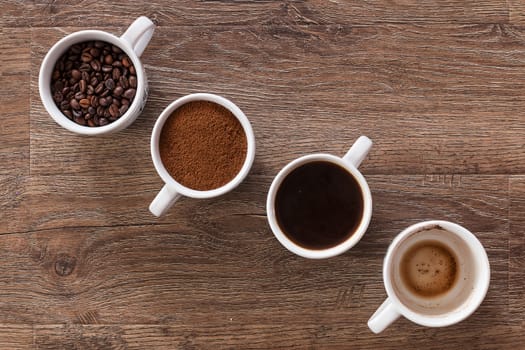 Four cups of coffee, phases of drink - bean, ground and empty cup