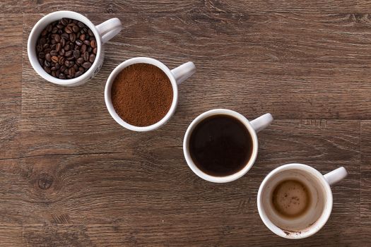 Four cups of coffee, phases of drink - bean, ground and empty cup