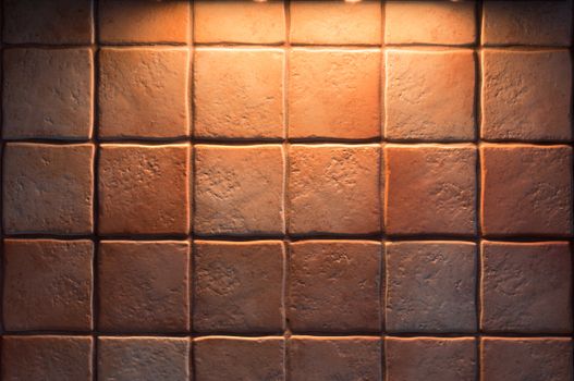 Texture of fine ceramic tiles for kitchen wall illuminated from above. Close up of tiled wall for background.