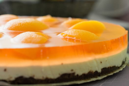 Homemade cheesecake with fresh apricot slices on the table