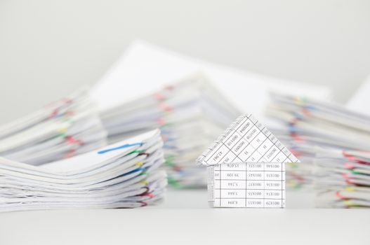 Close up house have blur pile overload paperwork of report and receipt with colorful paperclip place as background.