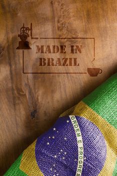 The predominant industry in Brazil - coffee. Flag of Brazil and hot stamp on wood Made in Brazil with a cup of coffee.