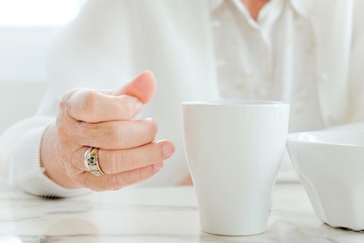 Close up image of senior women with drink, meal time