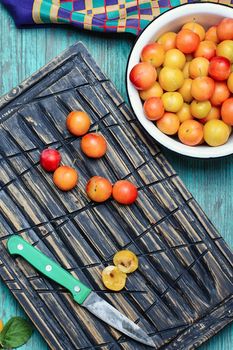 Iron bowl with autumn plums on wooden background