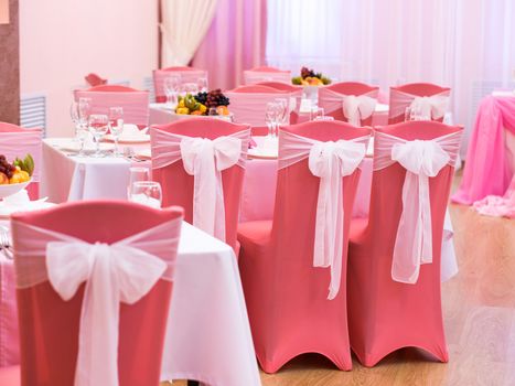 Close-up of white wedding chairs in pink color
