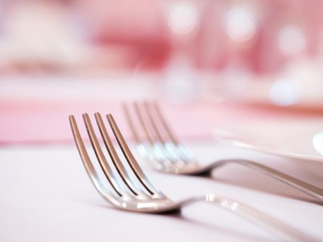 Two kitchen forks on dinner table. Selective focus. Shallow DOF