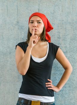 Young beautiful  woman has put forefinger to lips as sign of silence  or secrecy