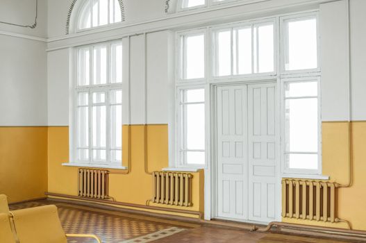 Old railway station waiting room with empty chairs.